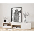 Modern living room with a white console table, books, and a framed 'BROADWAY' poster.