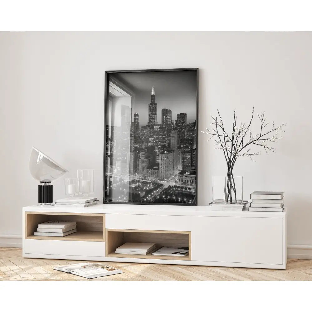 Modern living room with a white console table, books, and a framed cityscape print.