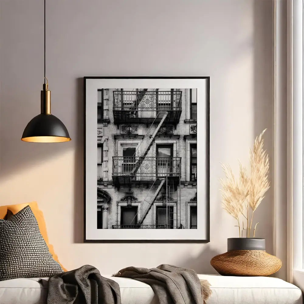 Framed black and white art print of a building exterior on a wall above a sofa.