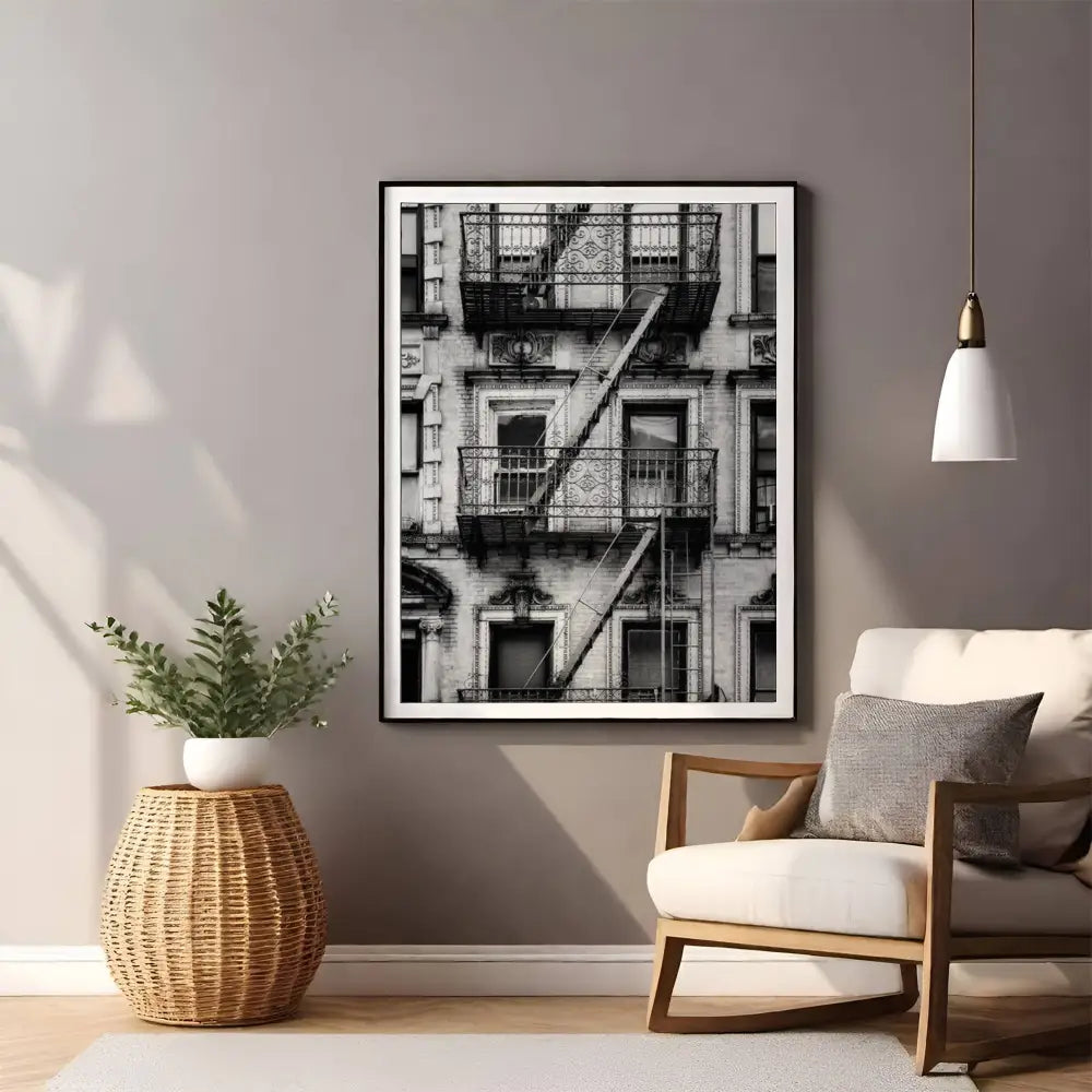 Framed black and white art print of a building staircase in a living room setting.