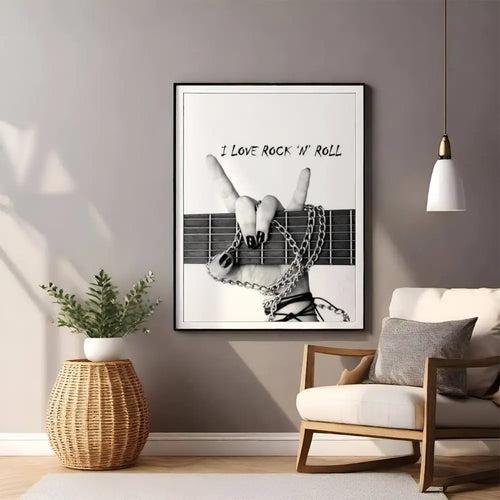 Living room with a framed poster of a hand on a guitar neck and 'I Love Rock 'n' Roll' text, a plant, and a chair.