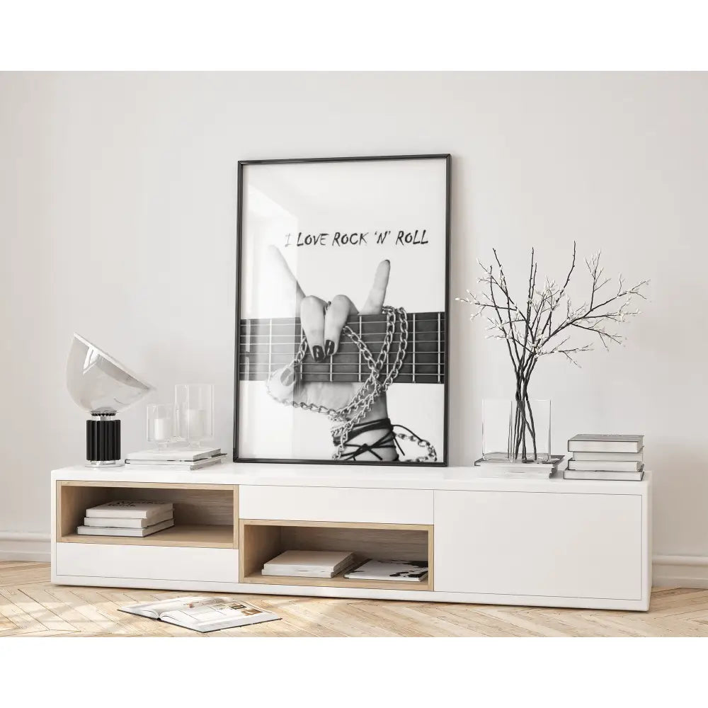 Modern living room with a white console table, books, and a framed picture of a hand holding a rock 'n' roll symbol.