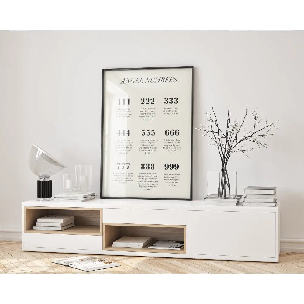 Framed 'Angel Numbers' print on a wall above a white console table with decor items.