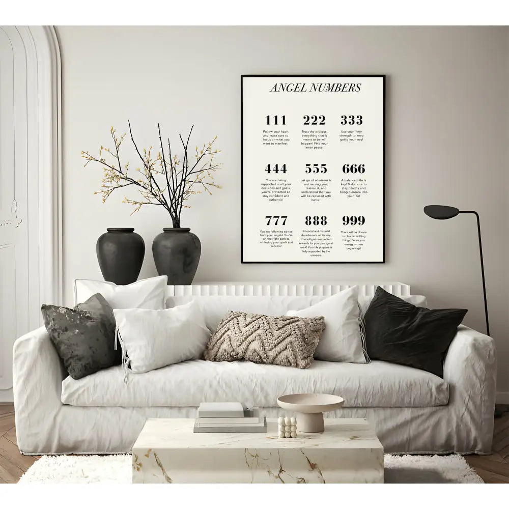 Living room with a white sofa, decorative pillows, and a framed poster titled 'Angel Numbers' on the wall.