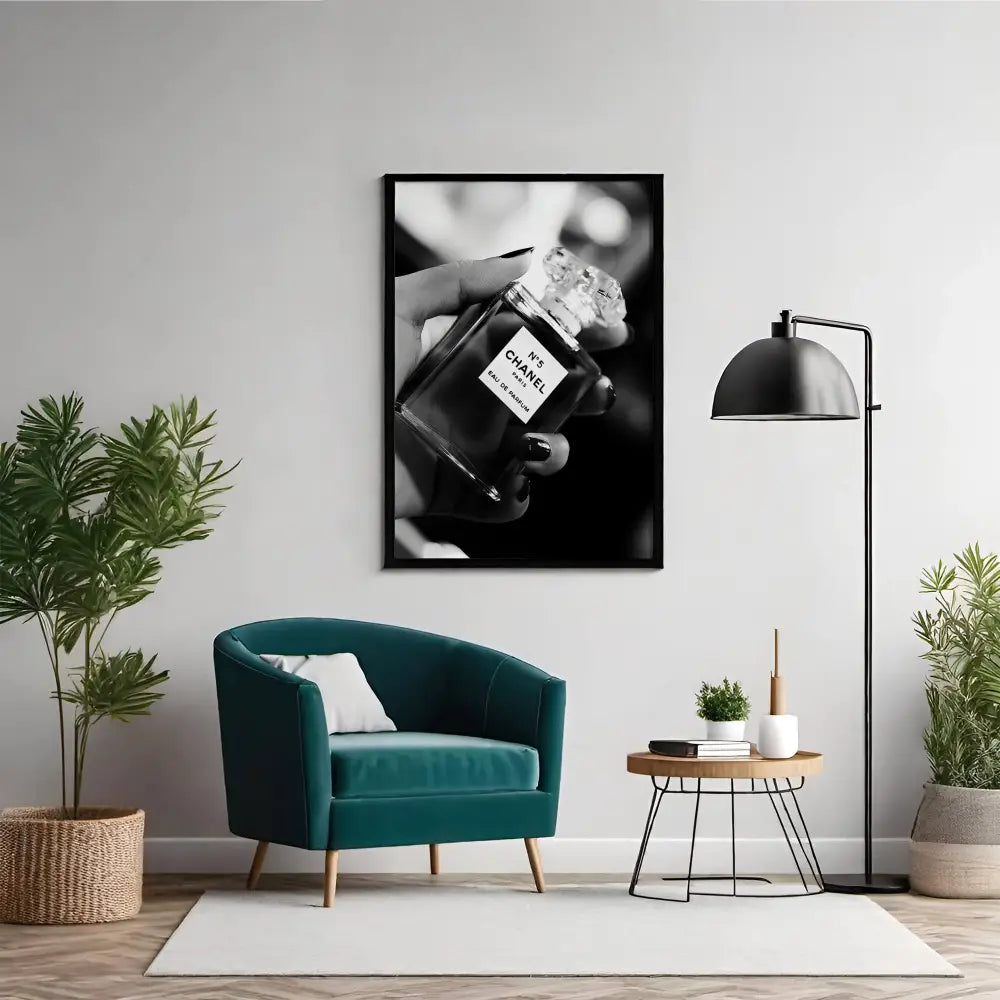 Modern living room with teal armchair, framed artwork of a hand holding a Chanel bottle, and decorative plants.