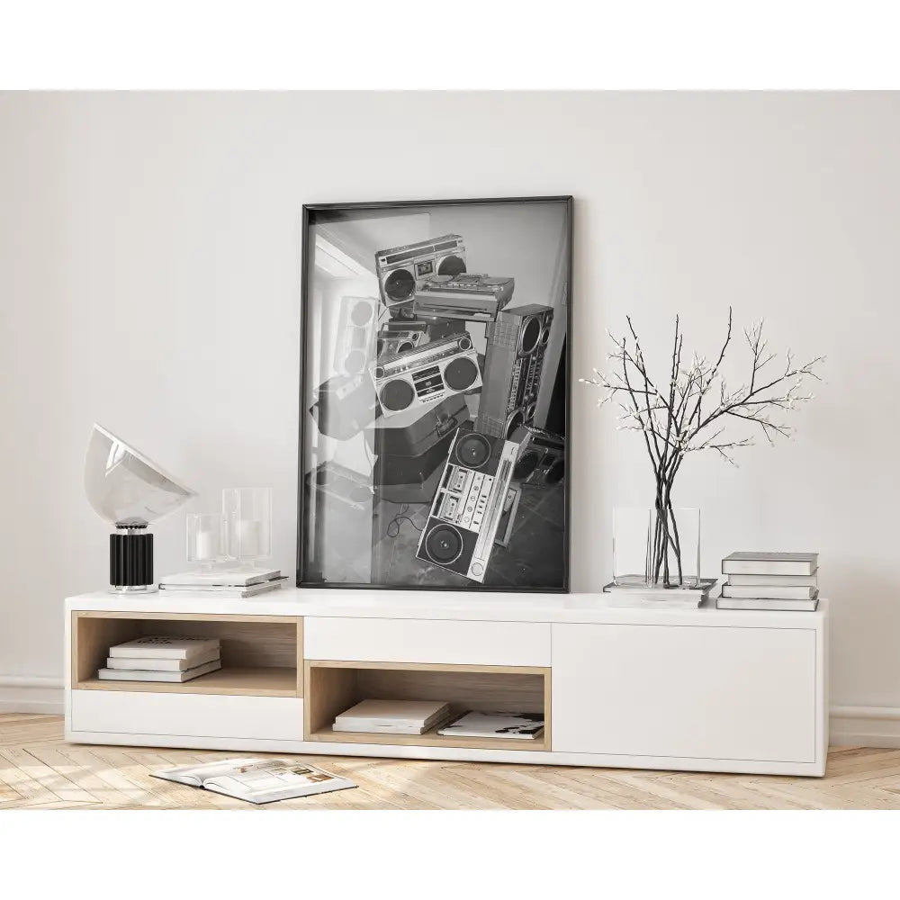 Modern interior with a white console table, books, and a black and white art print of vintage radios.