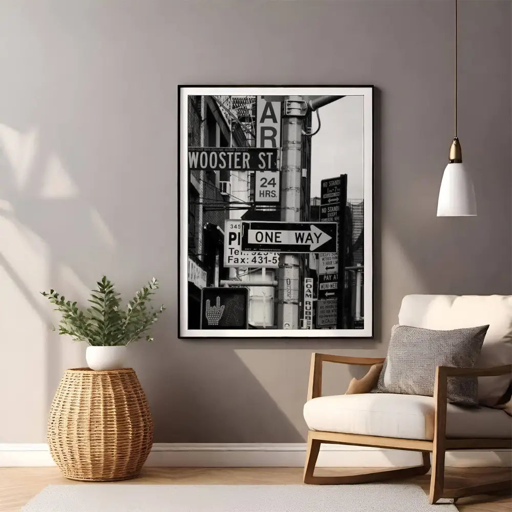 Framed black and white cityscape print on a wall above a chair and side table.