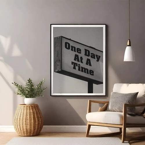 Framed artwork with 'One Day At A Time' quote in a living room setting.