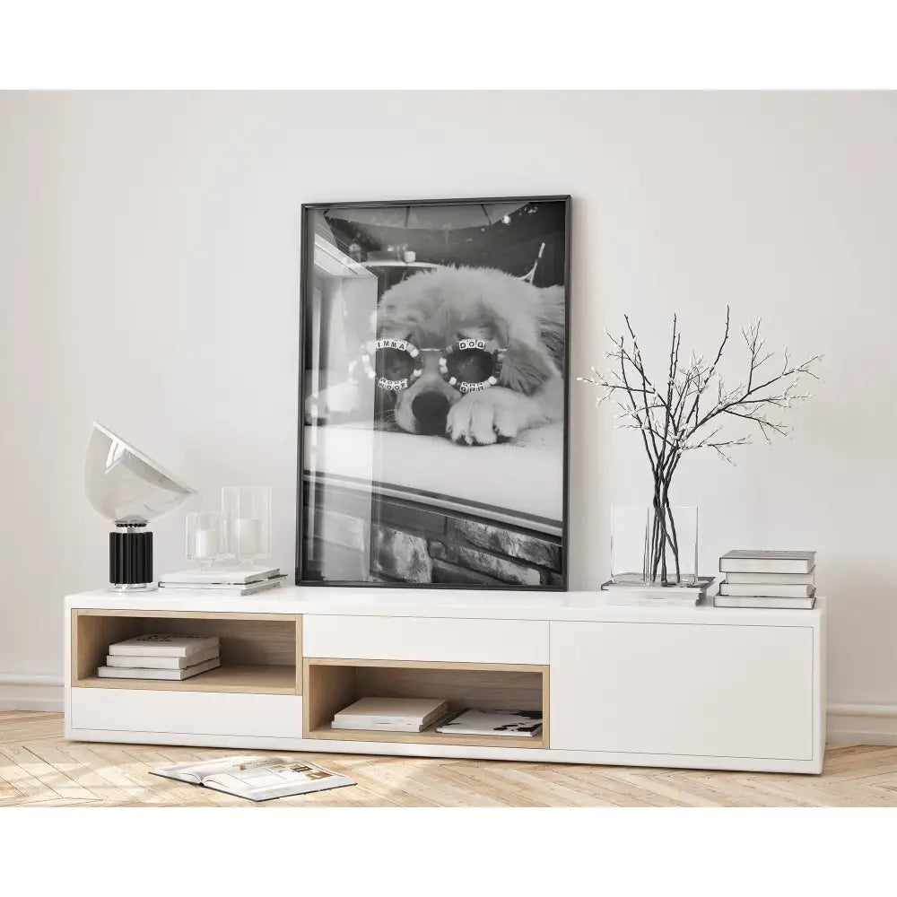 Modern living room with a white entertainment console, framed black and white photo of a dog, and decorative items.