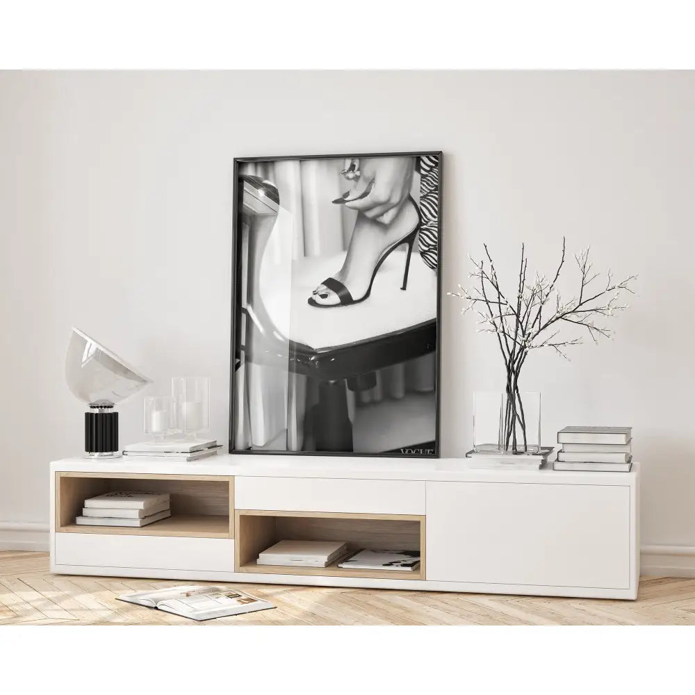 Modern interior with a white cabinet, books, and a black and white framed picture on the wall.