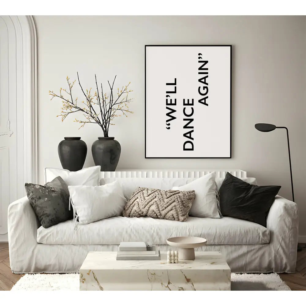 Living room with a white sofa, decorative pillows, and a framed quote on the wall.