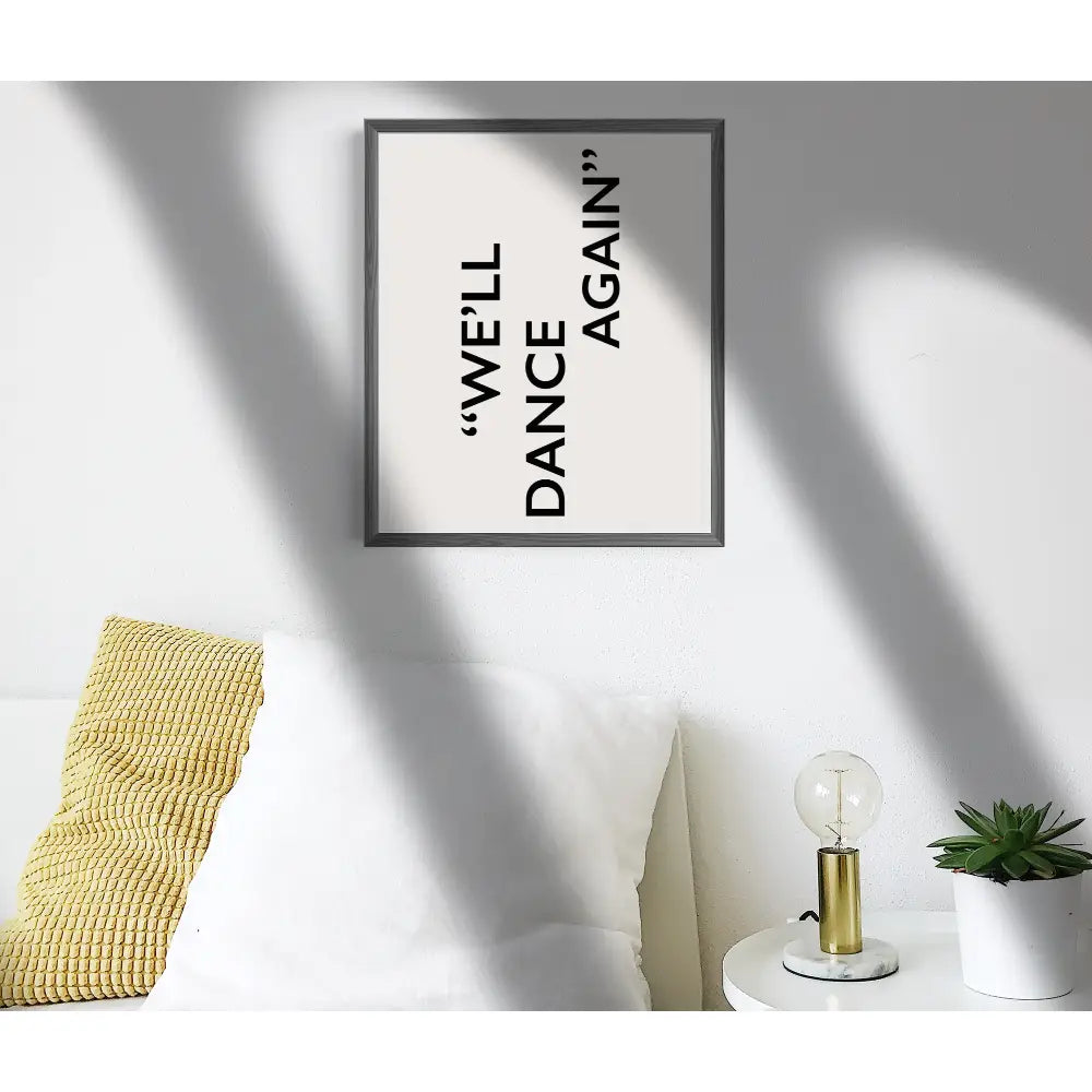 Framed artwork with text 'WELL DANCE AGAIN' on a wall with decorative elements.