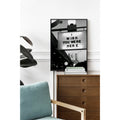Framed artwork with 'I Wish You Were Here' quote on a wall above a wooden dresser.